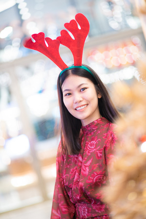 Beautiful women in santa costume posting with golden christmas tree winter holiday conceptの写真素材