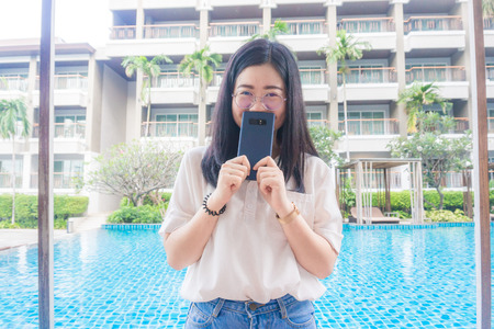 Beautiful asian smiling women posting with swimming pool of resort, Tourist women