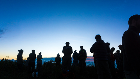 Silhouette group of people enjoying sunrise new year camping on mountain, New year new lifeの写真素材