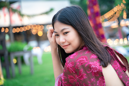 Beautiful asian women relaxing in park with party light bokeh festival backgroundの写真素材