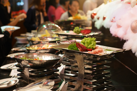 Lunch food buffet catering party with hand of people enjoying food serveの写真素材