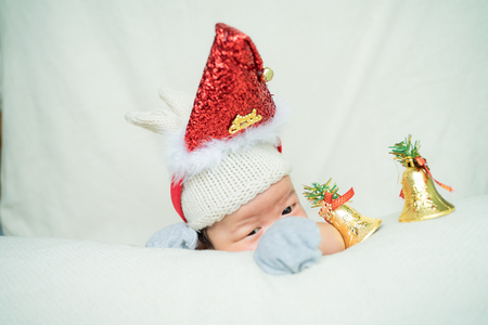 Infant baby christmas concept lying on white blanket with colorful ball decoration, Adorable babyの写真素材