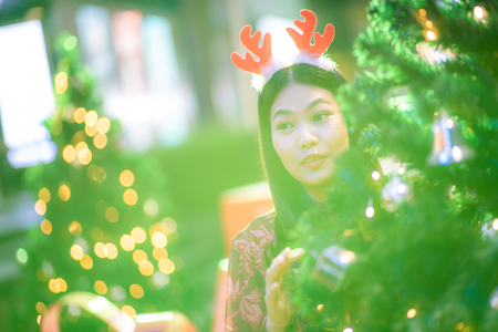 Beautiful asian christmas costume women with pine tree at nightの写真素材