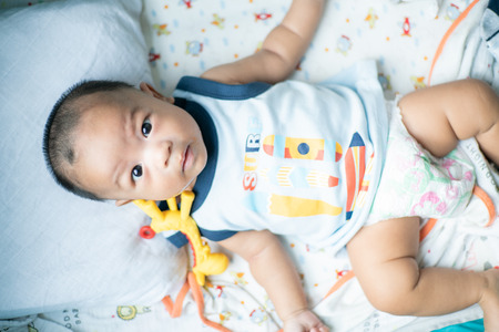 Infant baby boy chewing on teething with rubber bite toyの写真素材