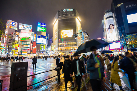 TOKYO, JAPAN -APRIL 11, 2017: Busy streets of Shibuya district in Tokyo with neon light while the rain at night, Japan. Shibuya is one of the shopping and financial districtsのeditorial素材