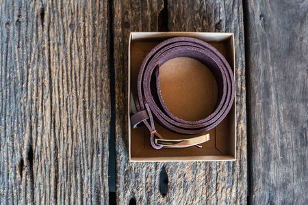 Leather belt hand crafts with solid brass buckle on wood tableの写真素材