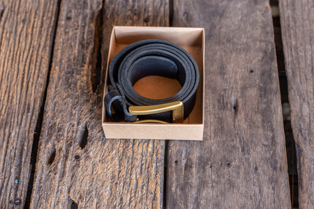 Leather belt hand crafts with solid brass buckle on wood tableの写真素材