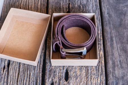 Brown leather belt handmade craftsmanship working on wood