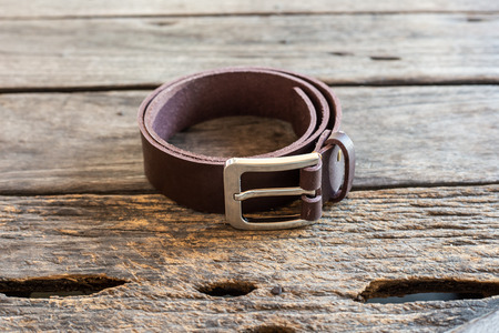 Brown leather belt handmade craftsmanship working on wood