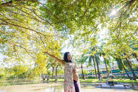 Pregnant beautiful women recreation in city public park under treeの写真素材
