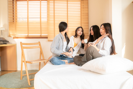 Fashion beautiful asian women group talking together on bed in room, Friend groupの写真素材