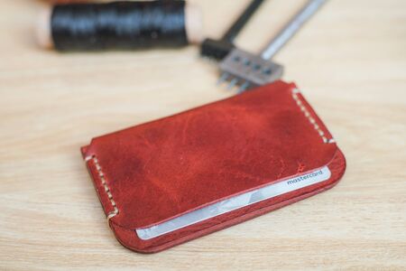 Genuine leather id card holder with tool on wood background
