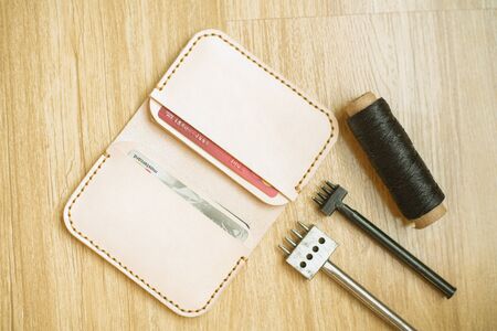 Leather card wallet craftsmanship on wood background
