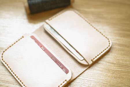 Leather card wallet craftsmanship on wood background