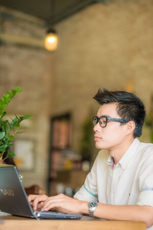 Business asian men working with laptop in coffee shop, Glasses men