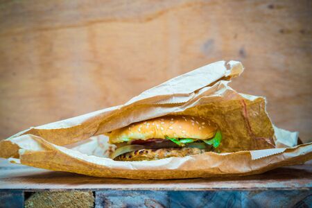 Good tasty homemade hamburger with vegetable in brown box on woodの写真素材