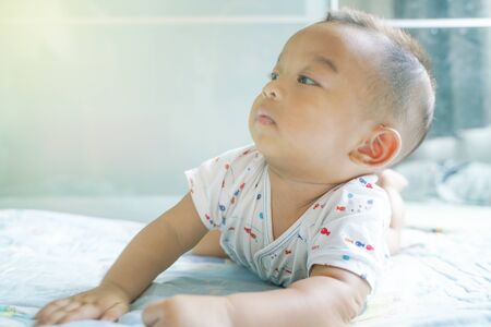 Funny baby boy crawling on blanket in bed room 6 month sonの写真素材