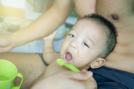Infant child boy trying eat food of vegetable and meat