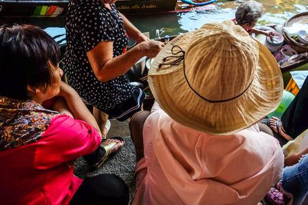 Floating market women in wooden boat trading food and beverage in morning, Thailandのeditorial素材