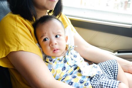 Asian boy travel with mother sitting on lap in car, Child boy travel