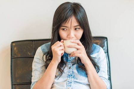 Beautiful asian women hold hot coffee cup in cafe drinking latte coffee