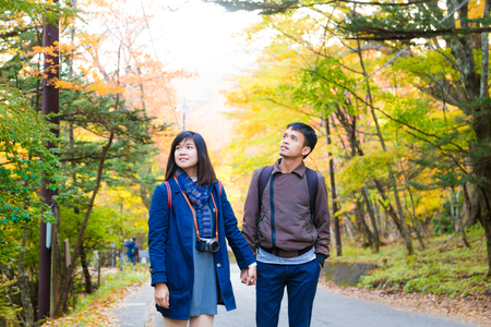 Asian couple of love enjoying autumn season colorful tree leaf travel conceptのeditorial素材