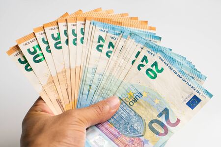 Pile bundle of euro money in business hand on white background, Business financeの写真素材