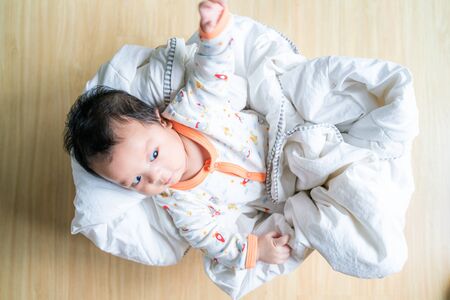 Adorable infant baby lying in wood basket with blanket, Newborn concept