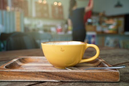 Hot latte art coffee on wood table in cafeの写真素材