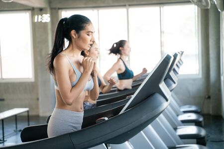 Group of sport asian women running on treadmill in gym
