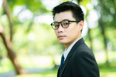 Attractive smart 30s asian business men in city public park nature friendly buciness conceptの写真素材