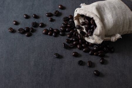 Dark roasted homemade coffee bean on black plate drink industryの写真素材