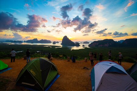Camping tent on hill of mountain sunrise sea bay trekking activity