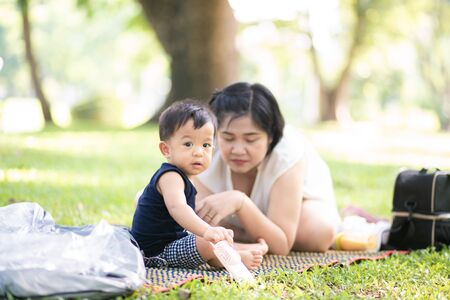 Mom playing with baby boy in city green park, Summer vacationの写真素材