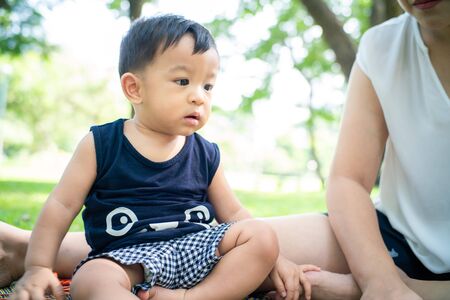 Mom playing with baby boy in city green park, Summer vacationの写真素材