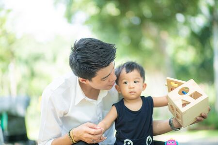 Father playing with baby boy after working in city park, Dad with boyの写真素材