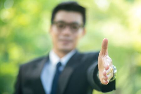 Handsome business man show blank hand in city park nature friendly conceptの写真素材