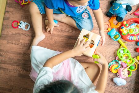 Funny kids group enjoying with wood toy in room education conceptの写真素材