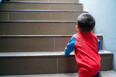 Funny baby boy crawling climbs up stair, Baby developmentの写真素材