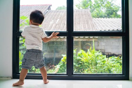 Baby toddler kids boy playing mirror window in modern house, Baby in new houseの写真素材