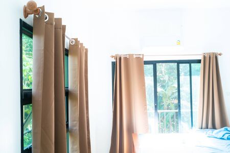 Beige curtain in cozy white bedroom interior decoration