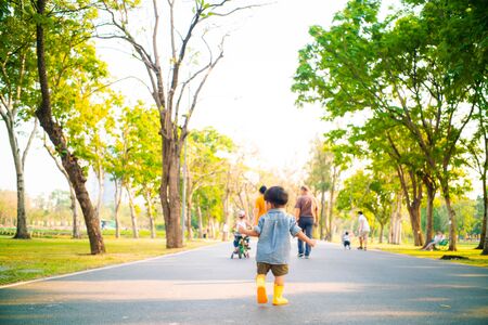Little asian boy try walking on green grass in public park sunset light, Baby boy in parkの写真素材