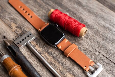 Craft working of leather watch strap on wood table