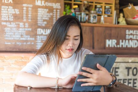 Business asian women using tablet computer comunication in cafe, Smiling womenの写真素材