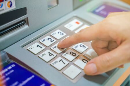 Hand entering on pin pad of ATM pass code business financeの写真素材