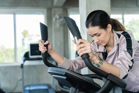 Attractive asian women be tired after cycling in fitness gym, Healthy lifestyle