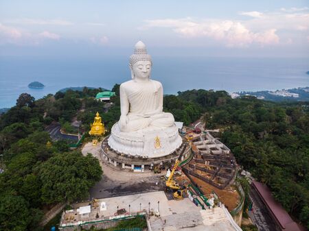Big white buddhist monk on top of mountain peak sunrise sky aerial view, Phuket Thailandの写真素材