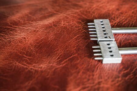 Leather working tool on genuine leather background craftsmanship working