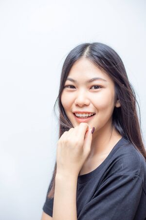 Beautiful happy asian woman portrait smiling wearing black shirt on white backgroundの写真素材