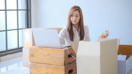 Business asian women package parcel box online sell with order from internet in living roomの写真素材